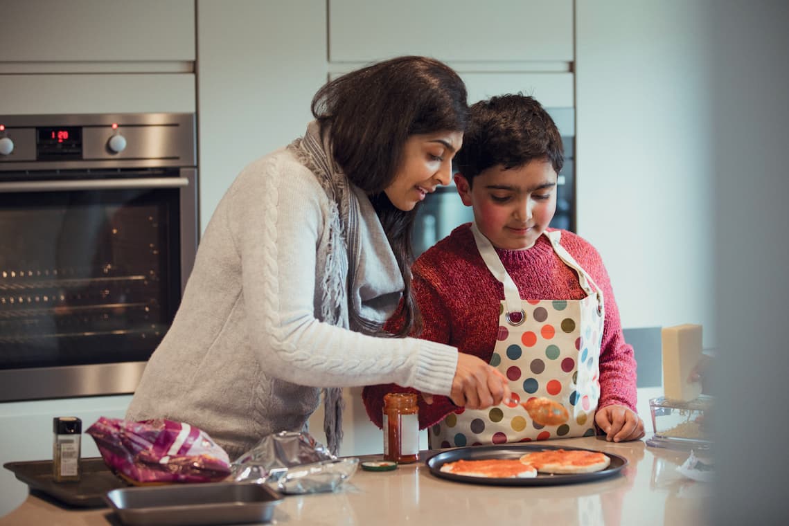 Femme aidant un enfant à cuisiner